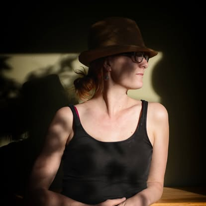 Abigale Stangl in profile, wearing a dark hat and looking to the side